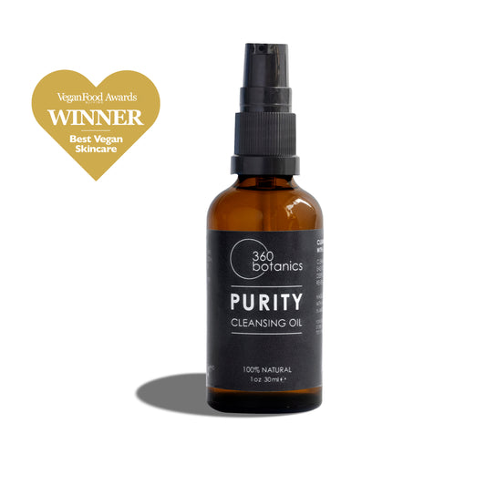 A 360 Botanics Purity Cleansing Oil bottle with a spray nozzle is displayed against a white background. Above the bottle is a golden heart graphic with the text 'Vegan Food Awards WINNER Best Vegan Skincare', signifying the product's quality and ethical accolades