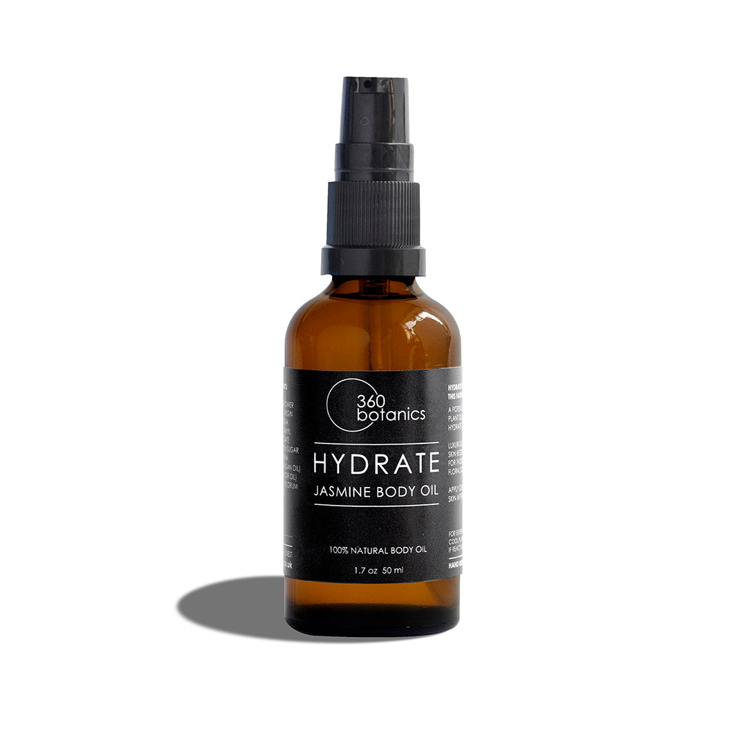 A 360 Botanics HYDRATE Jasmine Body Oil in an amber glass bottle with a spray pump, labeled in black and white, on a white background with a soft shadow to the right side of the bottle.