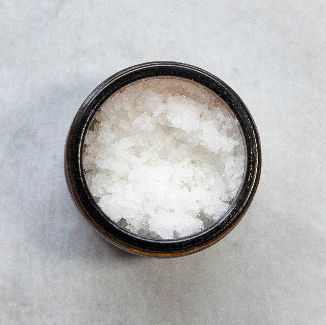 Sorbet Face Polish amber jar open photographed on grey marble