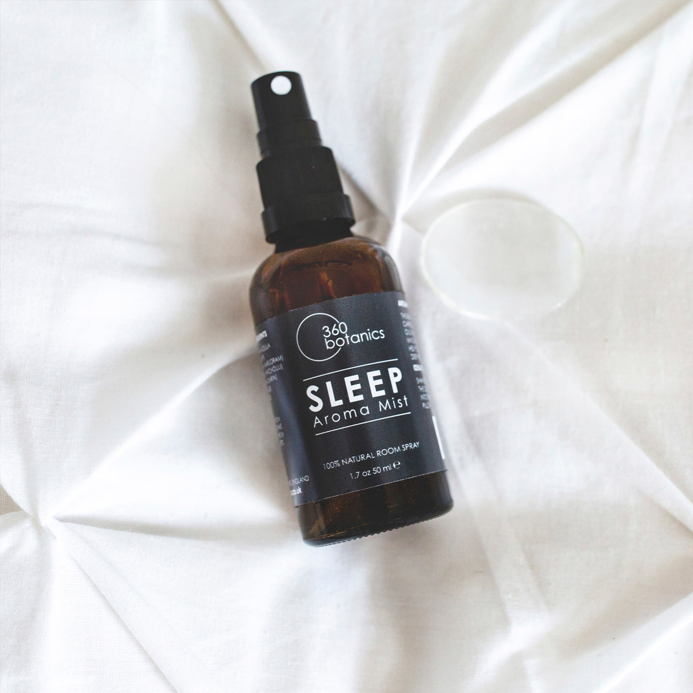Sleep Aroma Mist amber bottle on white duvet bedding