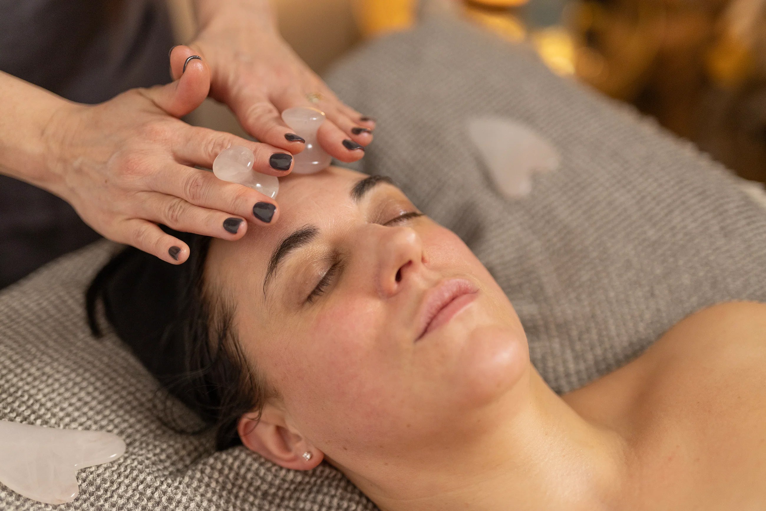 Client receiving a natural facial at 360 Botanics Spa in Lewes using rose quartz Gua Sha tools