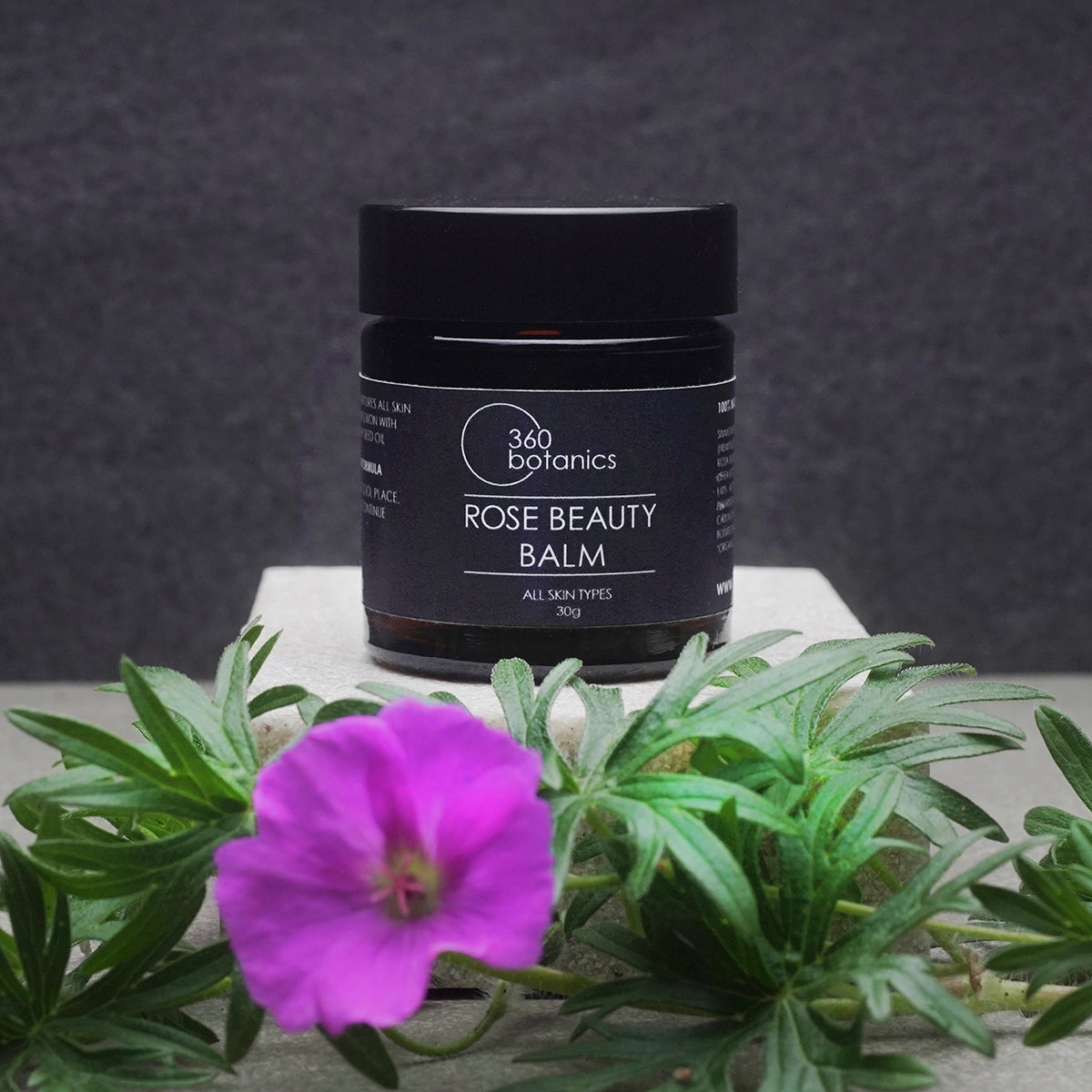 360Botanics-Rose-beauty-Balm on plinth with Geranium flower