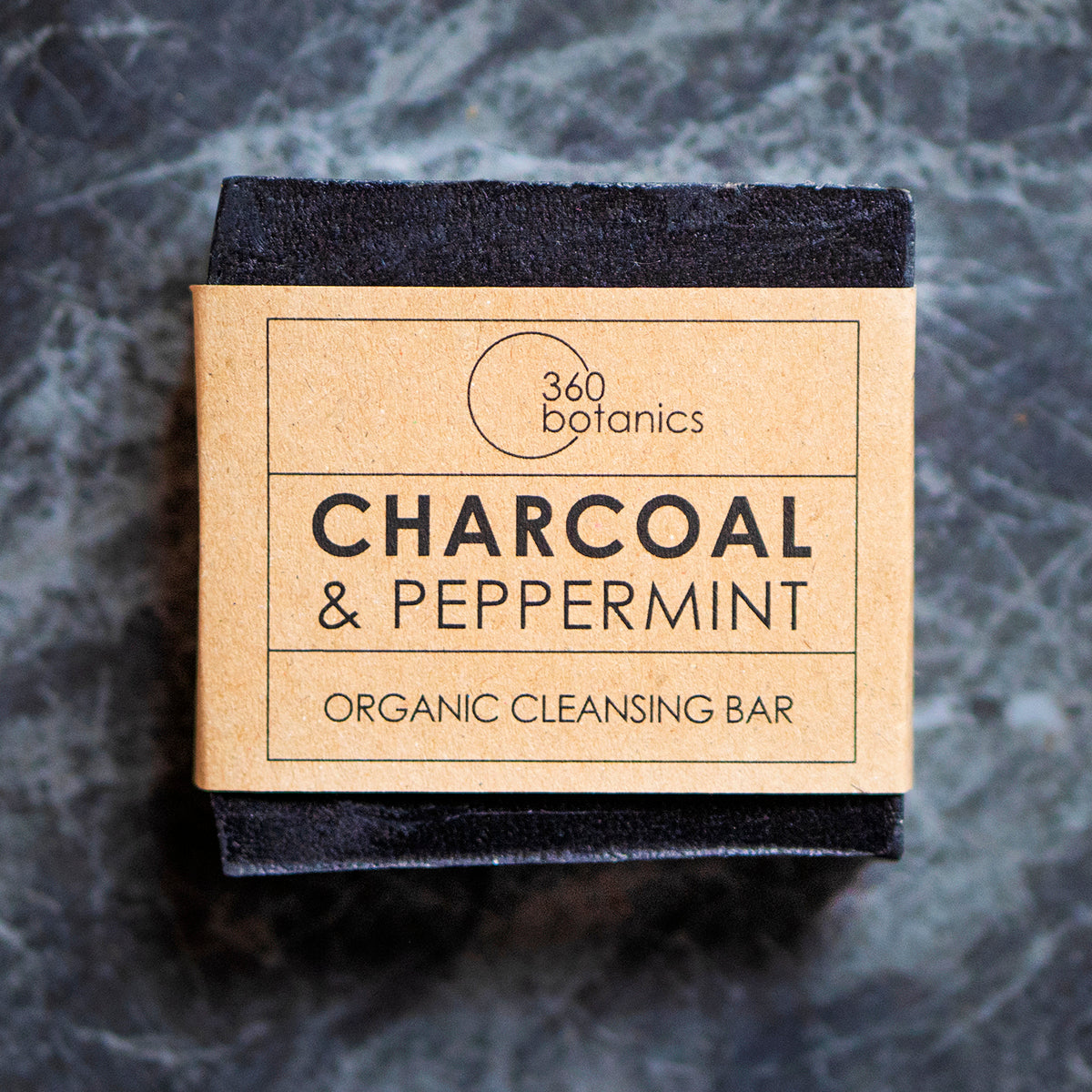 charcoal and peppermint black soap with kraft paper label photographed on grey marble
