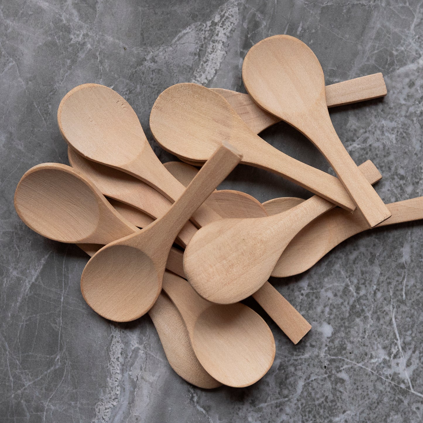 image of a pile of wooden spoons on a marble surface