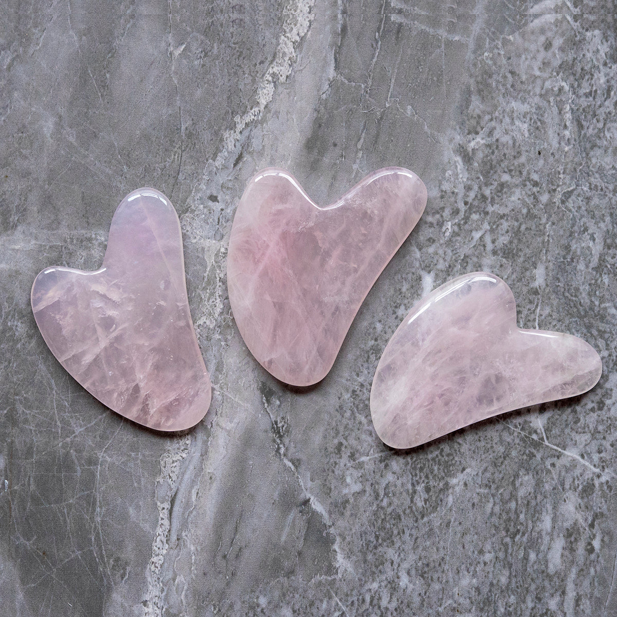 Rose Quartz Gua Sha tool on marble background