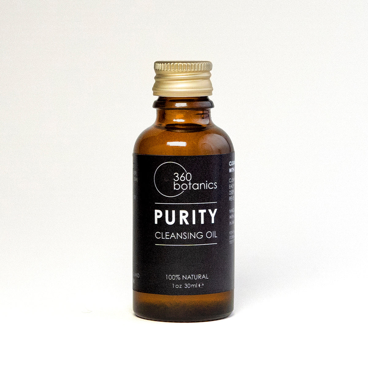 A bottle of 360 Botanics Purity Cleansing Oil on a neutral background, with a gold cap and clear labeling that reads '100% Natural, 1oz 30ml'. The simple and clean design conveys the product's natural ingredients and eco-friendly philosophy