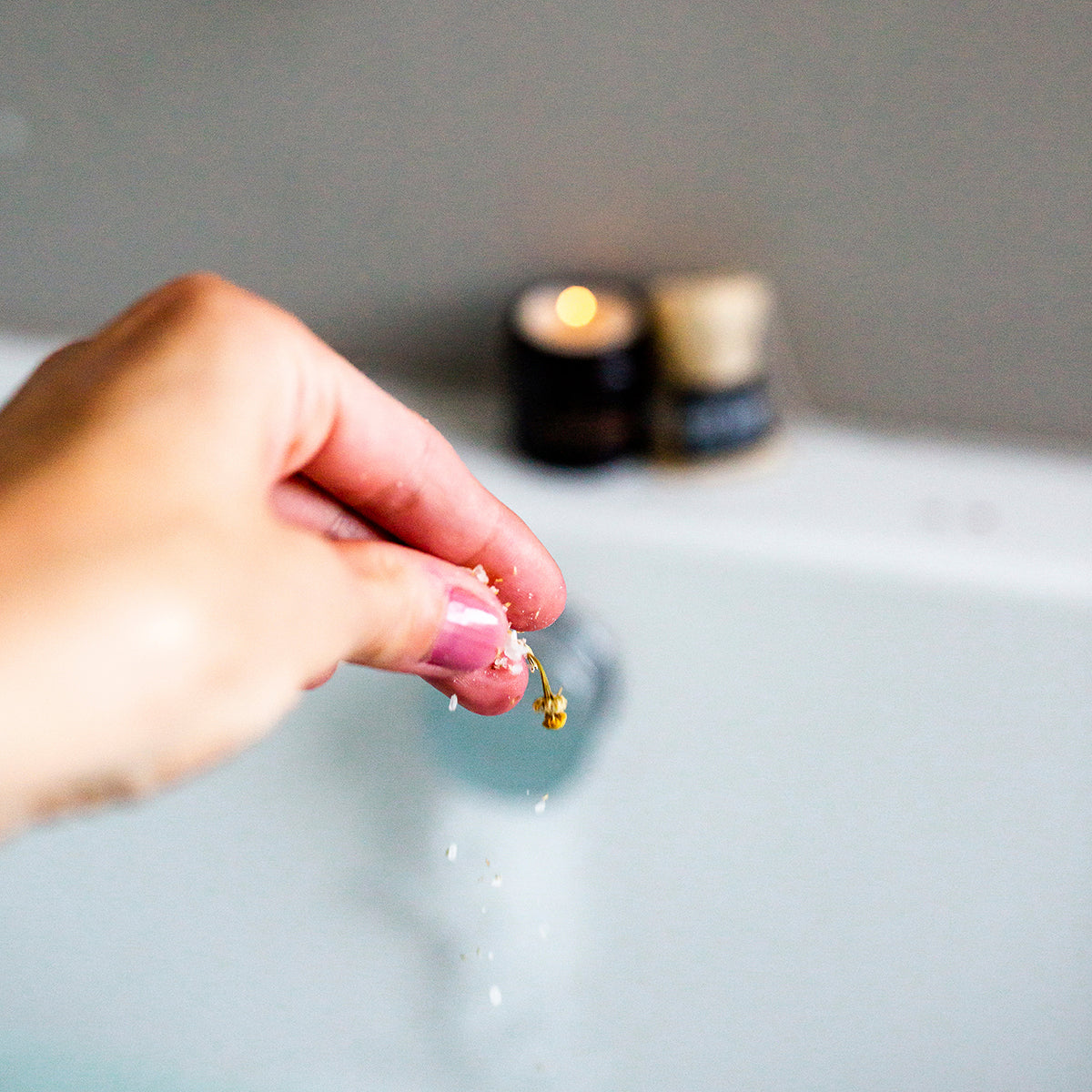 image of someones hands dropping bath slats into a bath